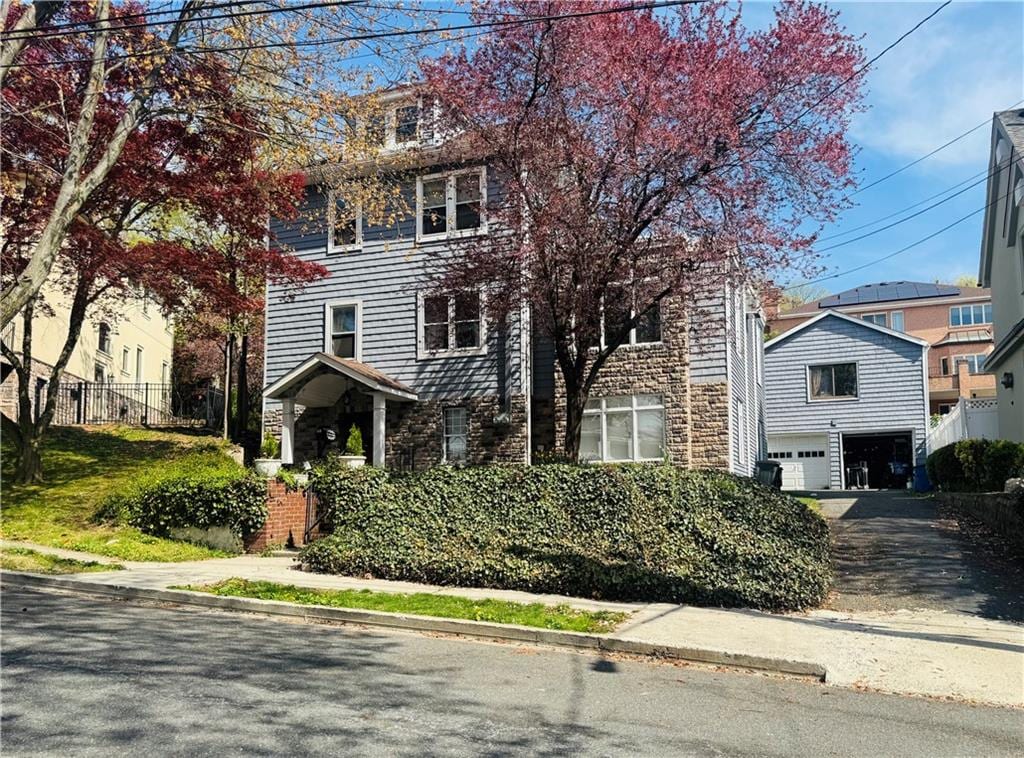 view of front of property featuring an attached garage, fence, and driveway