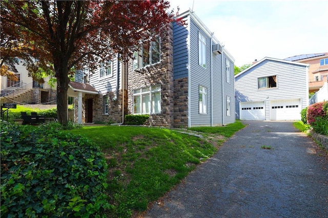 115 Wilson Ter, Staten Island, NY 10304 - view of home's exterior featuring stone siding, a garage, driveway, and a wall mounted AC