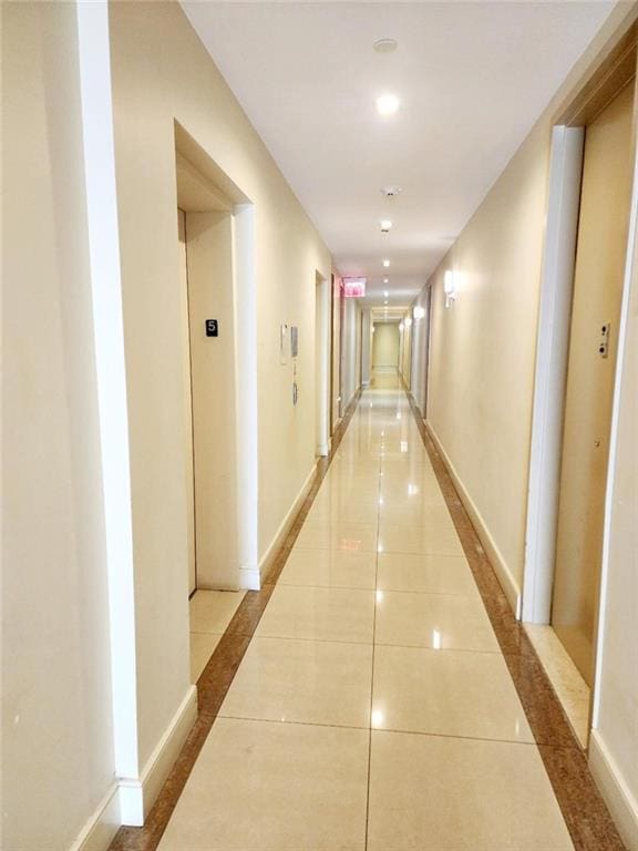 hallway featuring tile patterned floors and baseboards