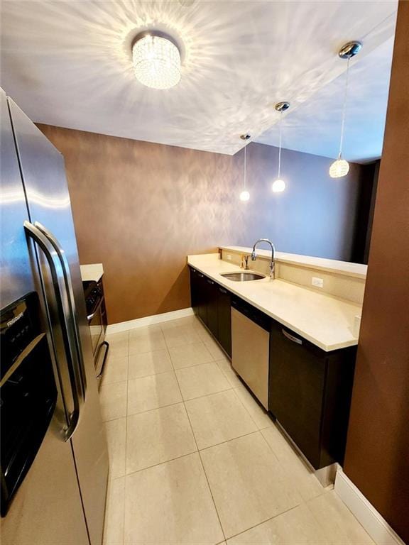 110 Neptune Ave Unit 3H, Brooklyn, NY 11235 - kitchen featuring appliances with stainless steel finishes, a sink, light countertops, baseboards, and light tile patterned floors