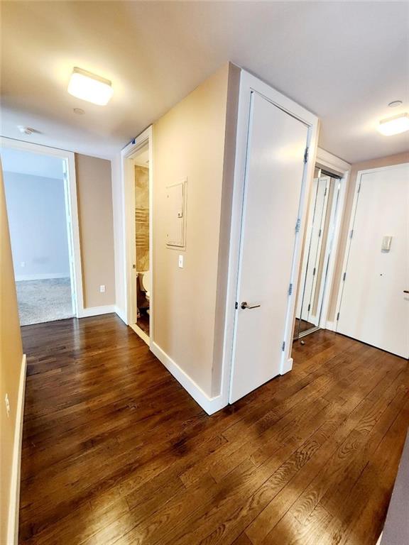 110 Neptune Ave Unit 3H, Brooklyn, NY 11235 - hall featuring wood finished floors, electric panel, and baseboards