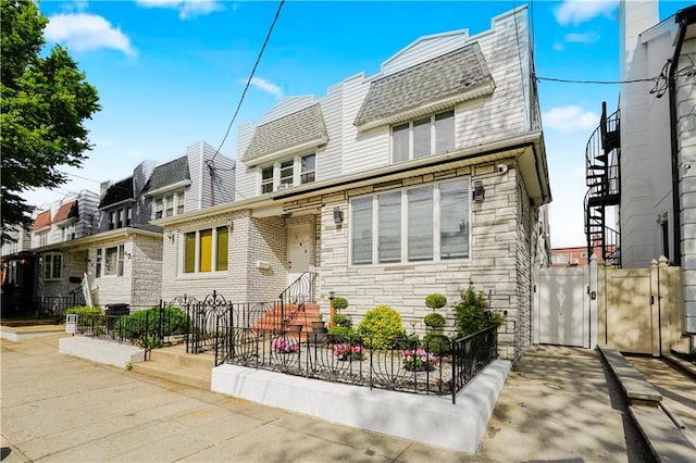 286 Bay 10th St, Brooklyn, NY 11228 - view of front of house with stone siding, mansard roof, a gate, a shingled roof, and a residential view