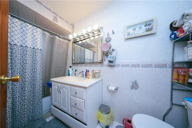 bathroom with toilet, tile walls, shower / bath combination with curtain, and vanity