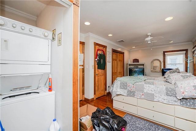 bedroom featuring visible vents, recessed lighting, stacked washer / dryer, and wood finished floors