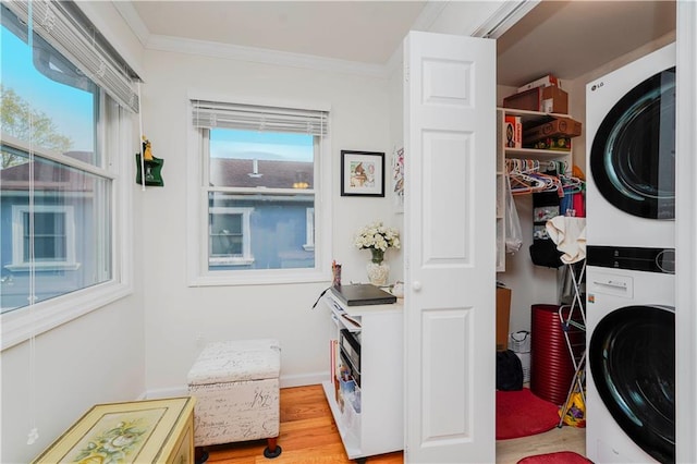 washroom with laundry area, stacked washer and clothes dryer, wood finished floors, and ornamental molding