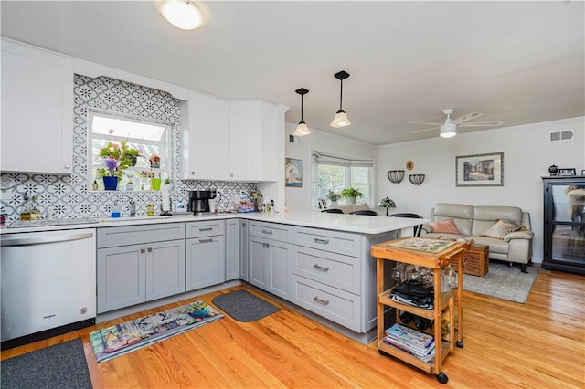kitchen featuring dishwashing machine, gray cabinets, a peninsula, and visible vents