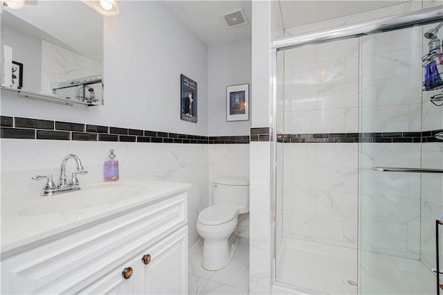 full bathroom featuring vanity, a stall shower, toilet, and visible vents
