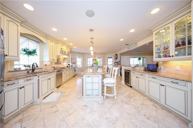 kitchen with stainless steel dishwasher, recessed lighting, a sink, and cream cabinets