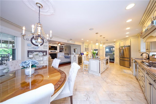 dining area featuring stone finish flooring, recessed lighting, a chandelier, and ornamental molding