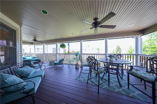 wooden terrace with a ceiling fan and outdoor dining area