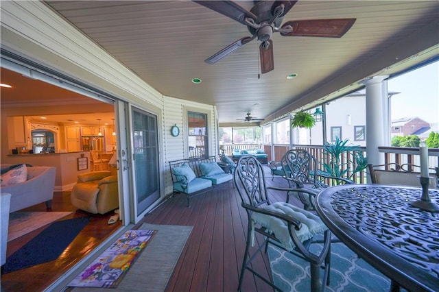 wooden terrace featuring outdoor dining area and a ceiling fan