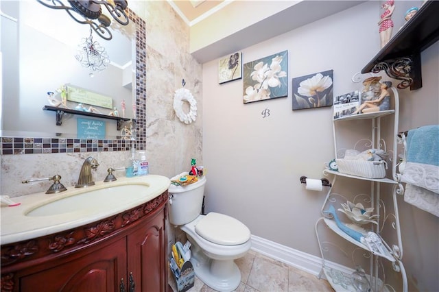 half bathroom with toilet, tile patterned floors, baseboards, and vanity