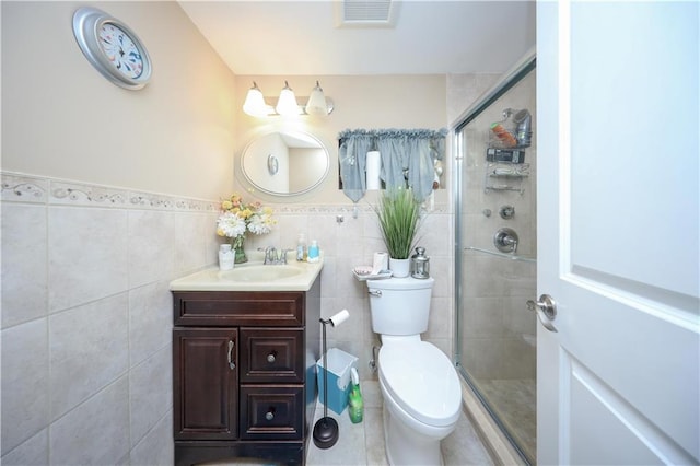full bathroom featuring visible vents, tile walls, a stall shower, vanity, and toilet