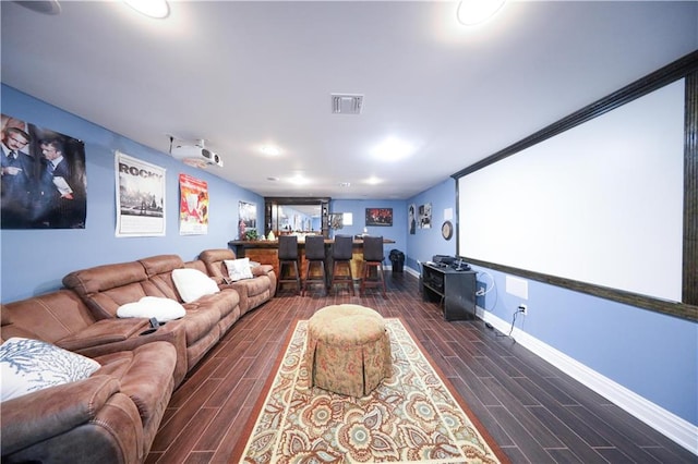 home theater room with visible vents, baseboards, bar area, and wood finish floors