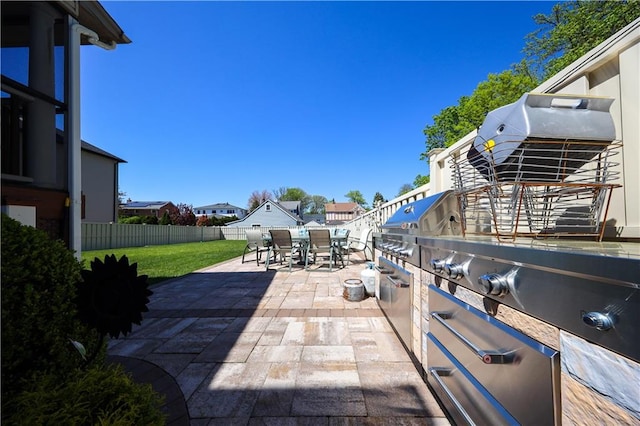 view of patio with fence, outdoor dining area, and area for grilling
