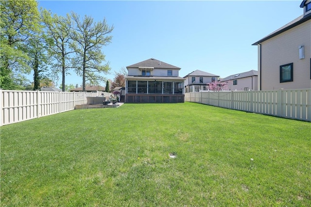 view of yard featuring a fenced backyard, an outdoor hangout area, and a sunroom