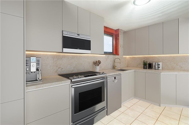kitchen featuring light countertops, dishwasher, a sink, and stainless steel range with electric stovetop