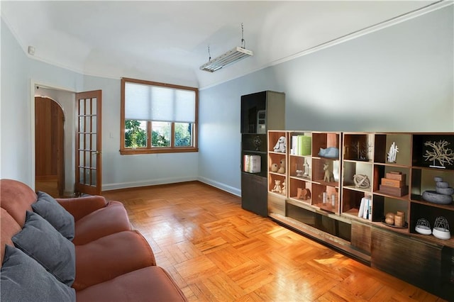 living area featuring baseboards and crown molding