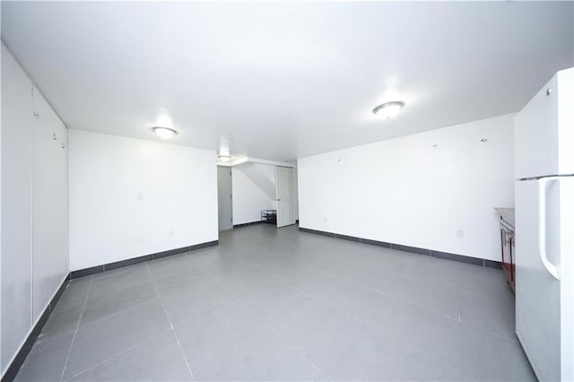 bonus room with baseboards and tile patterned flooring