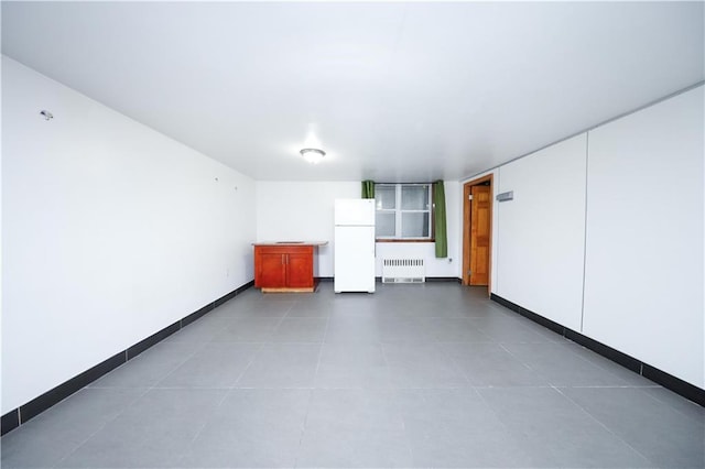 interior space featuring radiator, baseboards, and tile patterned flooring