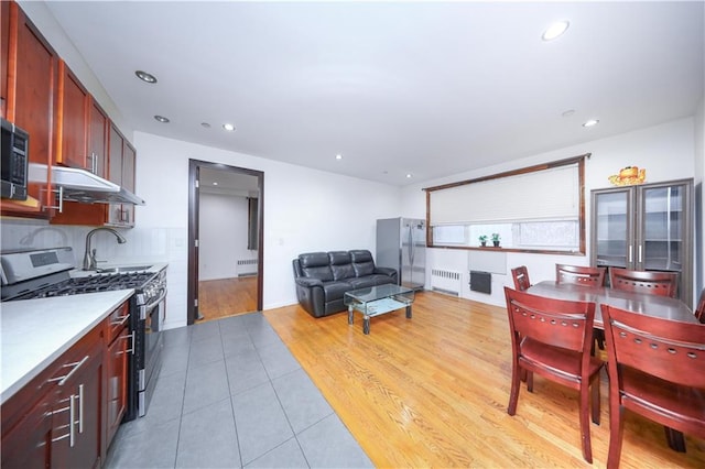 dining room featuring light tile patterned flooring, recessed lighting, and radiator