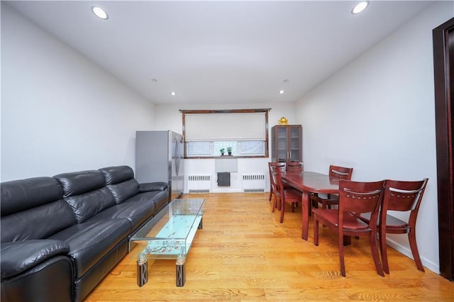 living room with light wood-type flooring, recessed lighting, and radiator heating unit