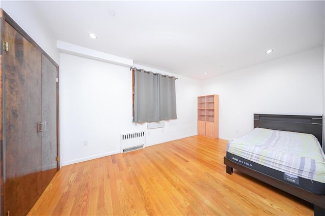 bedroom featuring recessed lighting, light wood-style flooring, radiator, and baseboards