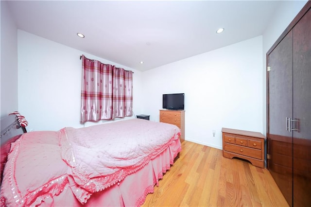 bedroom featuring light wood-type flooring, recessed lighting, baseboards, and a closet