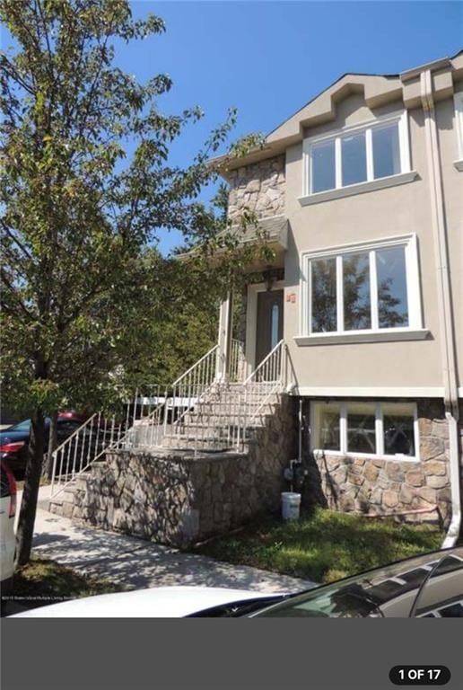 view of front of house with stucco siding and stone siding