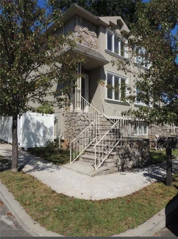 53 Calvanico Ln, Staten Island, NY 10314 - view of front of home featuring stone siding, stucco siding, and stairway