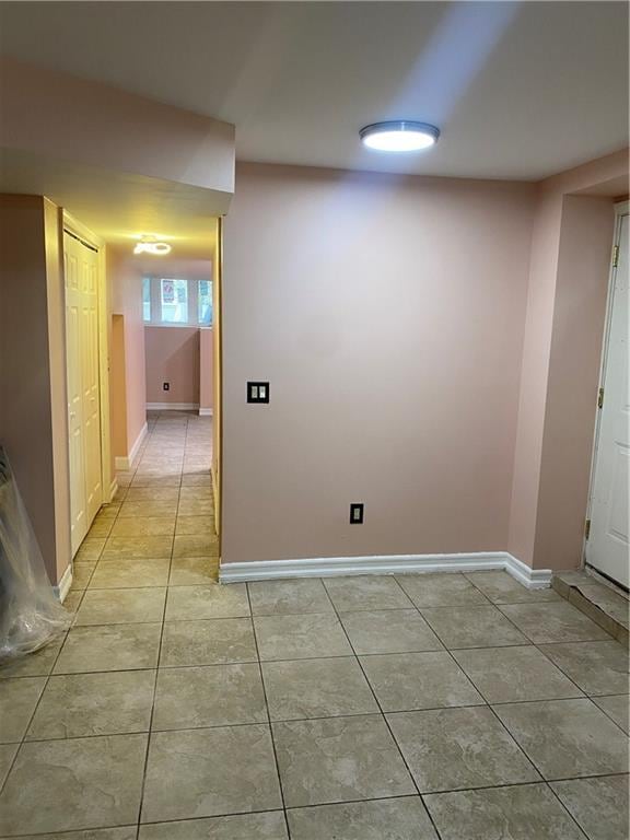 interior space with baseboards and light tile patterned flooring