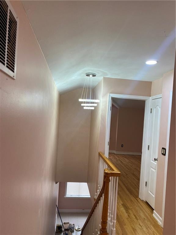 hall featuring light wood-style floors, recessed lighting, baseboards, an upstairs landing, and visible vents