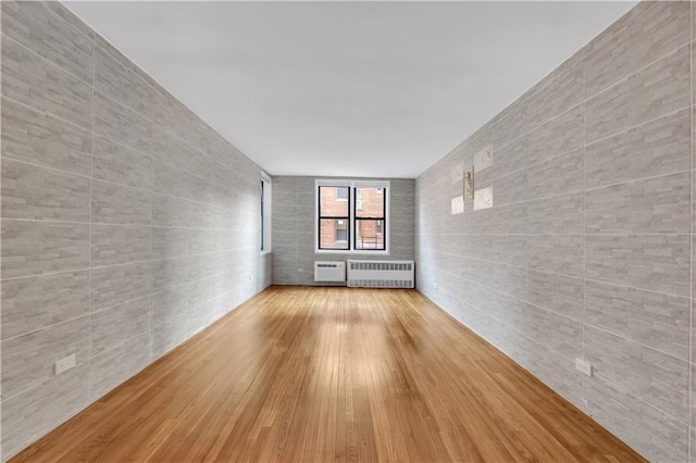 345 Webster Ave Unit 3N, Brooklyn, NY 11230 - empty room with radiator, tile walls, and wood finished floors