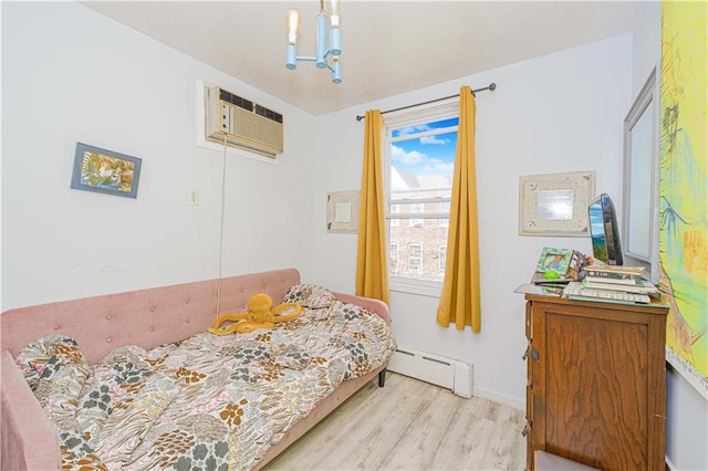 bedroom with light wood-type flooring, a baseboard radiator, and a wall unit AC
