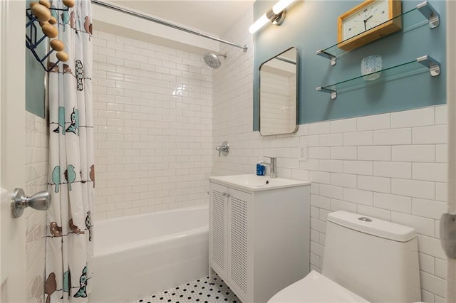 bathroom featuring shower / bath combo with shower curtain, vanity, tile patterned flooring, toilet, and tile walls