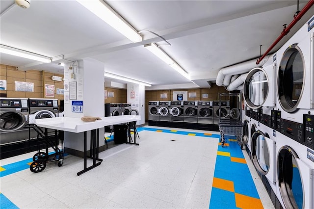 community laundry room featuring stacked washer and dryer, tile patterned floors, and washing machine and clothes dryer