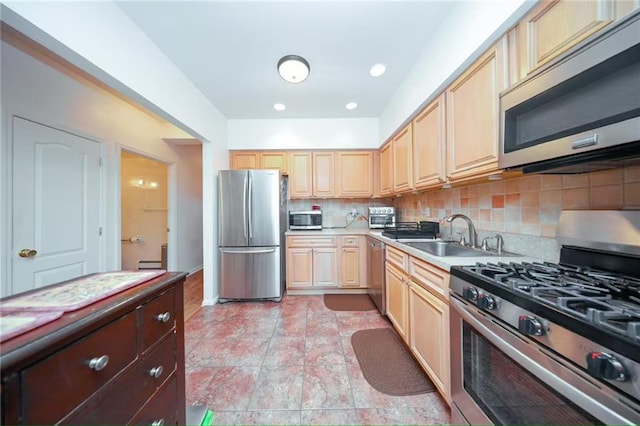 kitchen with light brown cabinetry, a sink, light countertops, stainless steel appliances, and backsplash