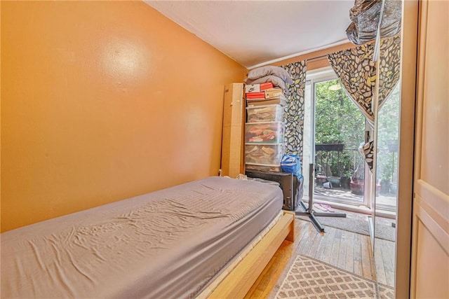 bedroom featuring wood finished floors and access to exterior