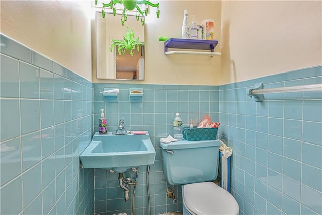 half bath with tile walls, toilet, and a wainscoted wall