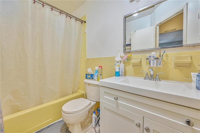 bathroom with tile walls, toilet, shower / bath combo, and vanity