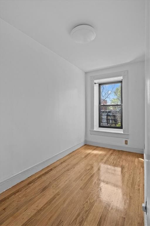 empty room featuring baseboards and light wood finished floors