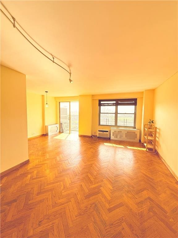 601 Surf Ave Unit 10H, Brooklyn, NY 11224 - spare room featuring baseboards, healthy amount of natural light, and a wall mounted air conditioner
