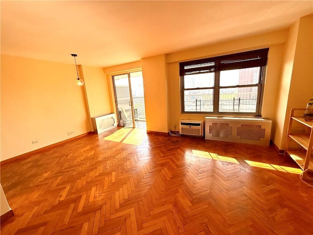 unfurnished room featuring baseboards, a wall mounted AC, and radiator heating unit