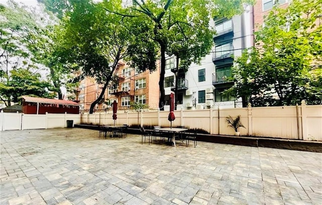 surrounding community with fence, outdoor dining space, and a patio