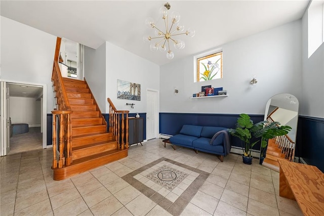 3 Silver Lake Rd, Staten Island, NY 10301 - living area featuring light tile patterned floors, a chandelier, stairs, a high ceiling, and baseboards