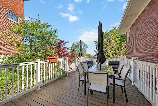 wooden terrace with outdoor dining area and outdoor lounge area
