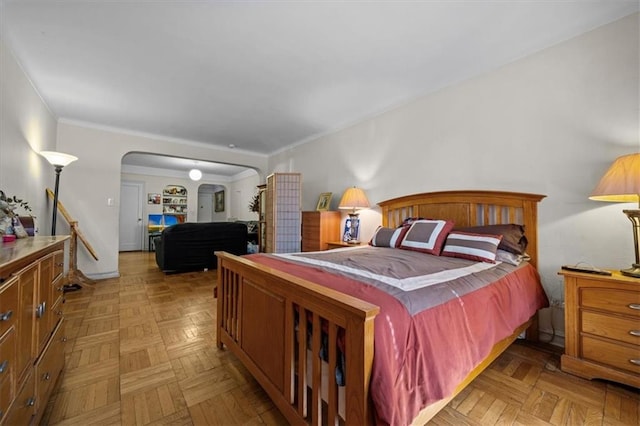 bedroom with crown molding and arched walkways