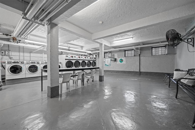 below grade area with a textured ceiling and washing machine and dryer