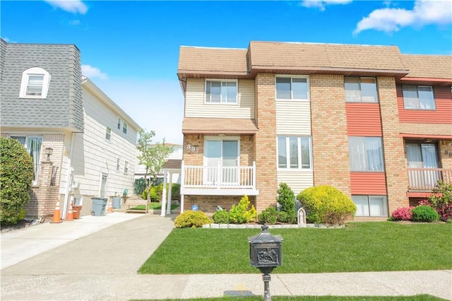 view of front of property featuring a front lawn and brick siding