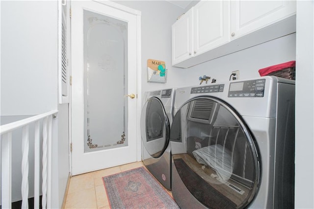 washroom featuring light tile patterned floors, cabinet space, and independent washer and dryer